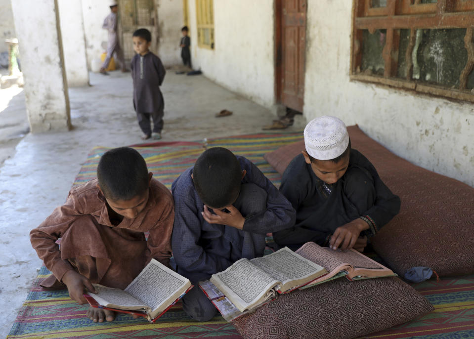 Nephews of Dawlat Khan an internally displaced tribal leader, reads verses of the Quran, on the outskirts of Jalalabad, Afghanistan, Wednesday, April 21, 2021. Khan fled his village of Pananzai with his six brothers and their families at the height of the battles against the Islamic State terror network. They're not rushing home, even though the family of 63 people is crammed into nine small rooms in Jalalabad. (AP Photo/Rahmat Gul)