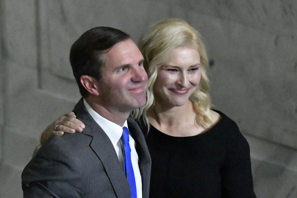 Kentucky Gov. Andy Beshear and his wife, Britainy, look toward the audience gathered in the Capitol Rotunda to witness him take the oath of office in Frankfort, Ky., early Tuesday, Dec. 12, 2023. (AP Photo/Timothy D. Easley)