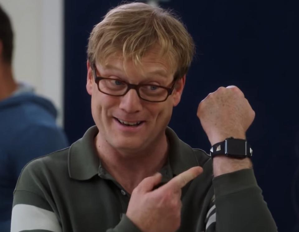 Andy Daly as Dave Kattertrune, pointing to an Apple Watch bracelet that had pyramid studs