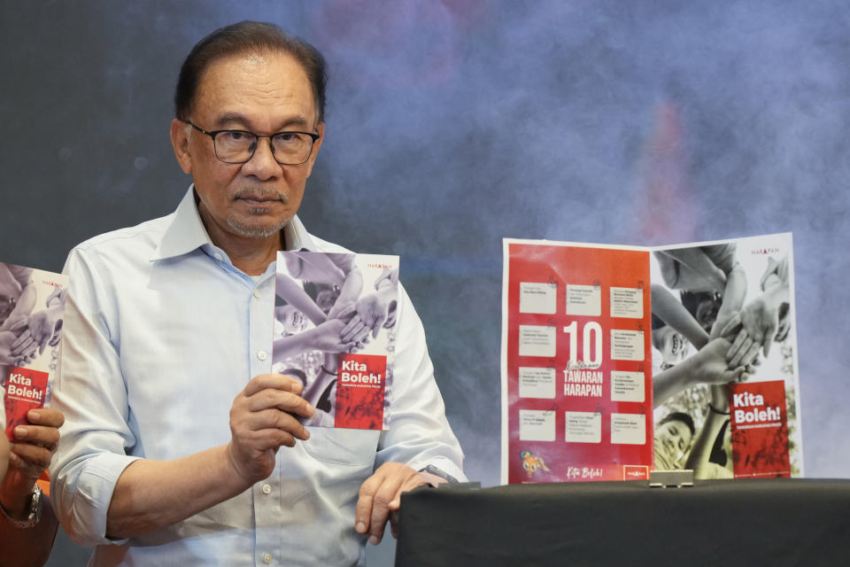 Malaysian opposition leader Anwar Ibrahim shows a copy of manifesto of his Pakatan Harapan (The Alliance of Hope) at a hotel in Klang, Malaysia Wednesday, Nov. 2, 2022. National elections will be held on Nov. 19. (AP Photo/Vincent Thian)