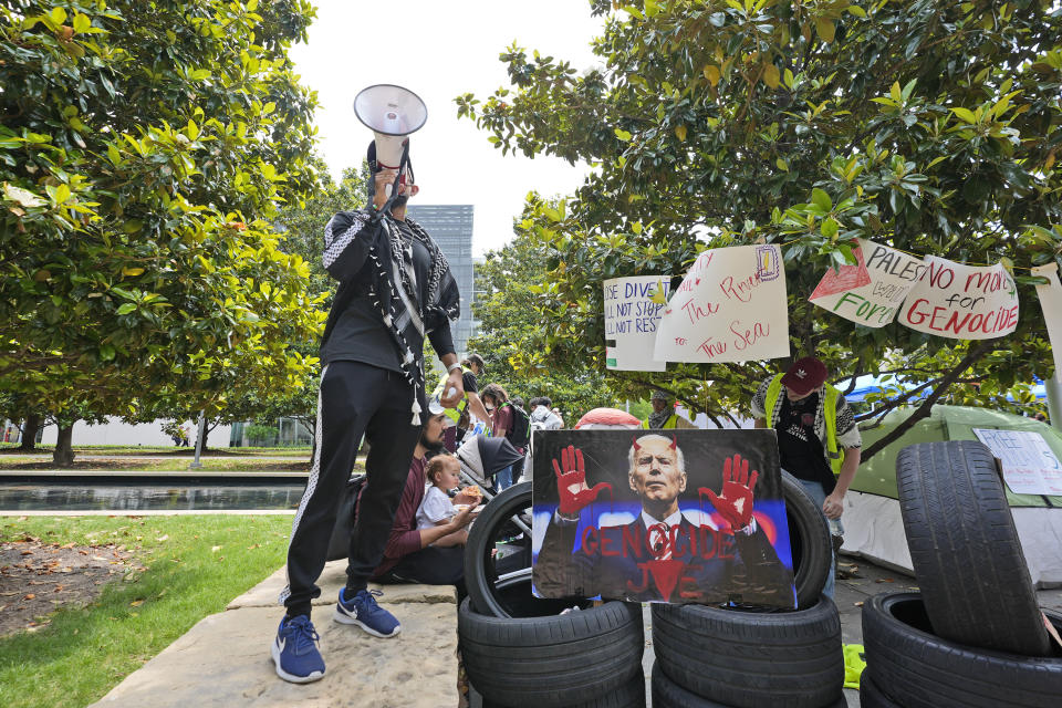 A man uses a megaphone to chant against the Israel-Hamas war at a protest site set up at the University of Texas at Dallas, Wednesday, May 1, 2024, in Richardson, Texas. (AP Photo/LM Otero)