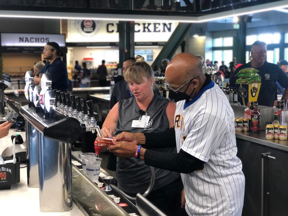 Cecil Cooper serves drinks to patrons during a "Tap Takeover" at American Family Field Friday, Aug. 5, 2022. Members of the 1982 Brewers team, commemorating the 40th anniversary of their World series run, were on hand for a pregame celebration.