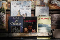 Books are displayed at a bookseller booth, called "bouquiniste" along the Seine Riverbank in Paris, Tuesday, Aug. 22, 2023. The host city of Paris vowed to deliver an extraordinary grand opening on July 26, 2024, as the ceremony is expected to draw about 600,000 spectators to the Parisian quayside. Citing security measures, the Paris police prefecture ordered on July 25 the removal of 570 stationary boxes out of which booksellers have operated for decades on the quays of the Seine river. (AP Photo/Sophie Garcia)