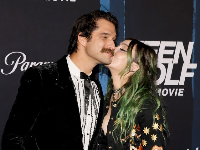 <p>Kevin Winter/GA/The Hollywood Reporter via Getty</p> Phem kisses Tyler Posey on the cheek at the "Teen Wolf: The Movie" premiere in January 2023