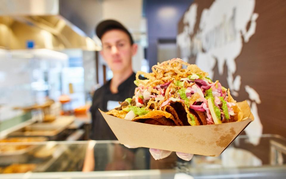 A chef from Compass Group's Restaurant Associates serves up vegan nachos - Compass Group