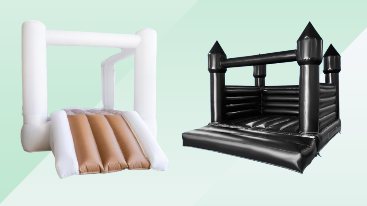 A white bounce house with a slide and black bounce house castle