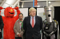 Bobby Smith, a political and fathers' rights activist and founder and leader of the 'Give Me Back Elmo' party, left, and Independent candidate Count Binface stand either side of Britain's Prime Minister and Conservative Party leader Boris Johnson wait for the Uxbridge and South Ruislip constituency count declaration at Brunel University in Uxbridge, London, Friday, Dec. 13, 2019. (AP Photo/Kirsty Wigglesworth)