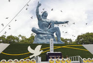 Doves fly over the Peace Statue during a ceremony to mark the 77th anniversary of the U.S. atomic bombing at the Peace Park in Nagasaki, southern Japan Tuesday, Aug. 9, 2022. (Kyodo News via AP)