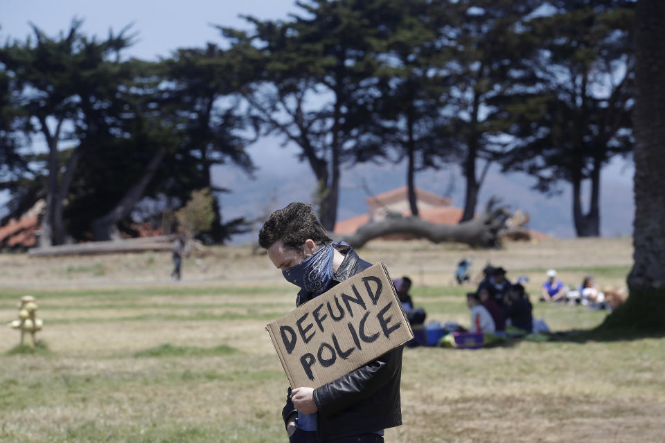 Niko Van Dyke holds a sign that reads Defund Police as he listens to speakers at a protest calling for an end to racial injustice and accountability for police in San Francisco, Sunday, June 21, 2020. (AP Photo/Jeff Chiu)