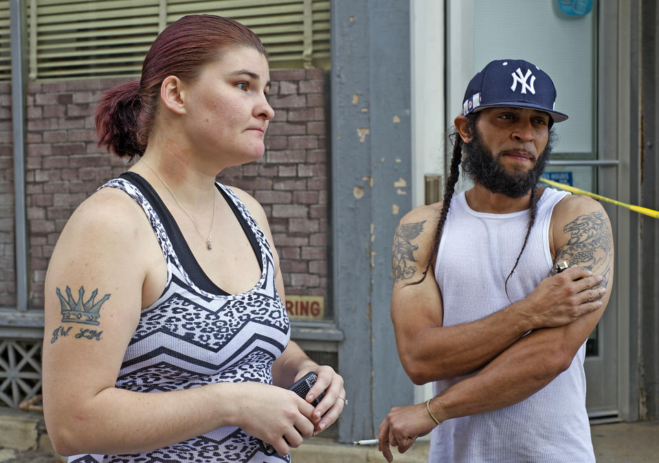 Stephanie Connelly of Allentown, Pa., describes the details of being near the explosion Sunday, Sept. 30, 2018, beside boy friend Waldemar Colon of Allentown, as police nearby join members of the ATF and the FBI around 11 am, hours after a fiery car explosion rocked the neighborhood on Saturday. Police confirmed at least one fatality and at least 50 investigators remain on the scene scouring for evidence. (Harry Fisher/The Morning Call via AP)