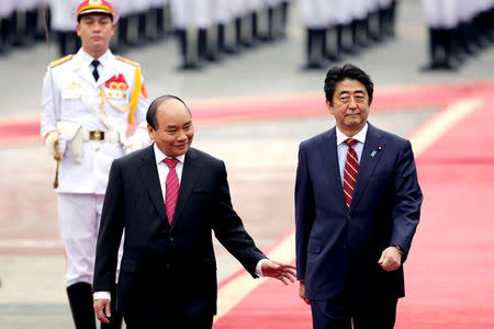 Japanese Prime Minister Shinzo Abe (R) and his Vietnamese counterpart Nguyen Xuan Phuc (L) review an honor guard at the Presidential Palace in Hanoi, Vietnam January 16, 2017. REUTERS/Luong Thai Linh/Pool