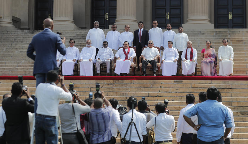 Sri Lankan president Gotabaya Rajapaksa, seated fifth from right, sits for photographs with his new cabinet members in Colombo, Sri Lanka, Friday, Nov. 22, 2019. Rajapaksa, who was elected last week, said he would call a parliamentary election as early as allowed. The parliamentary term ends next August, and the constitution allows the president to dissolve Parliament in March and go for an election. (AP Photo/Eranga Jayawardena)