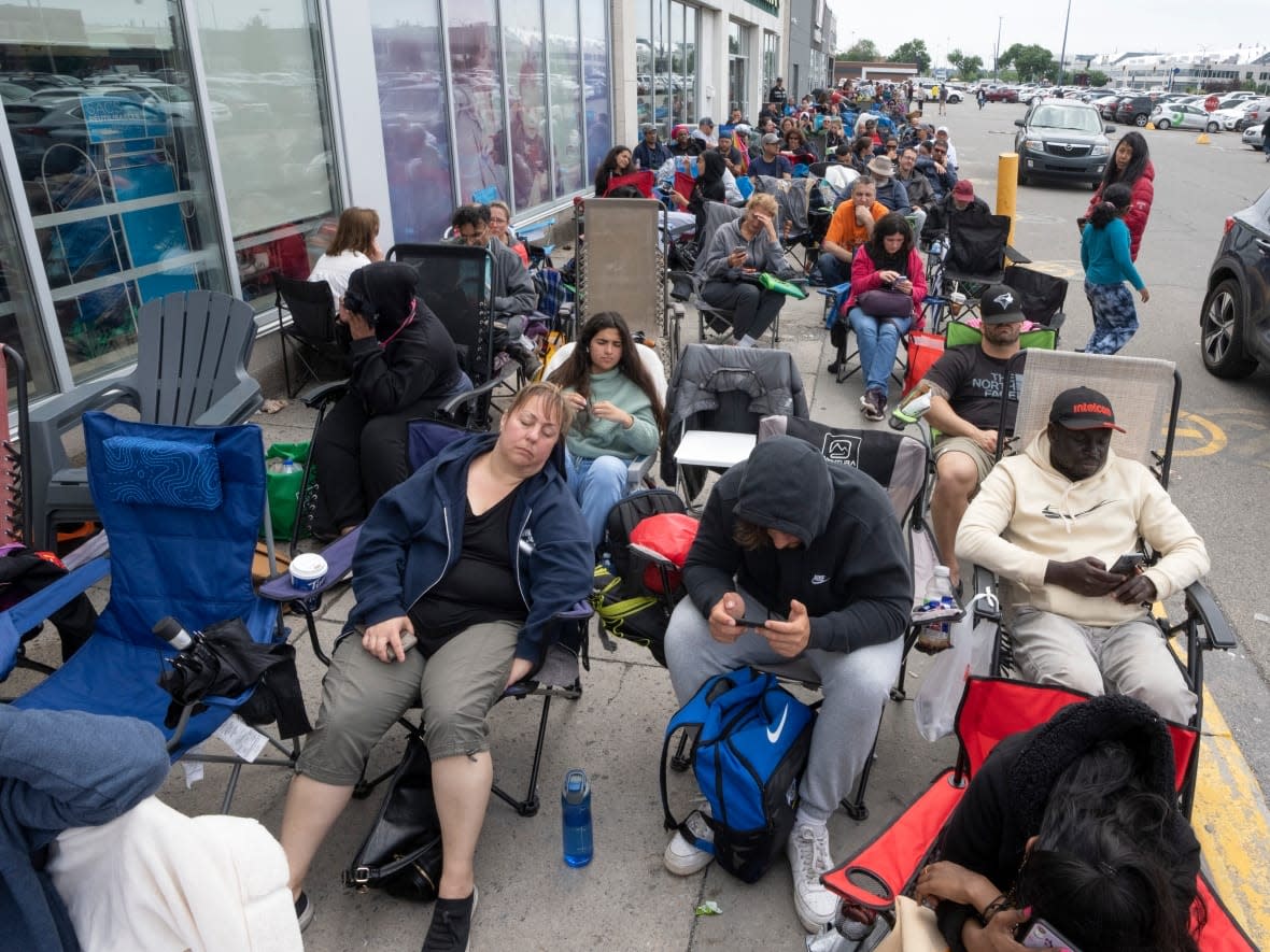 People line up at a passport office in Montreal on June 22. Delays in passport processing continue to disrupt Canadians' travel plans. (Ryan Remiorz/The Canadian Press - image credit)