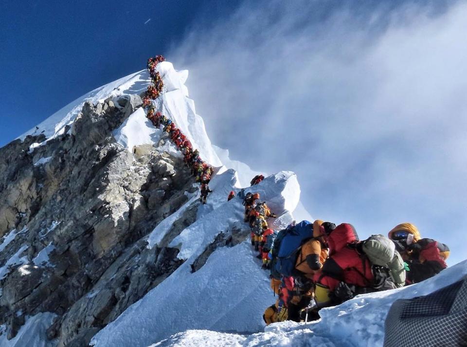 In this photo made on May 22, 2019, a long queue of mountain climbers line a path on Mount Everest. About half a dozen climbers died on Everest last week most while descending from the congested summit during only a few windows of good weather each May. (Nimsdai Project Possible via AP)