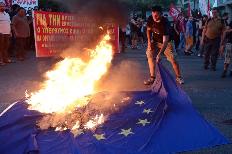 A protester burns an EU flag outside the European Comission offices in Athens on July 2, 2015