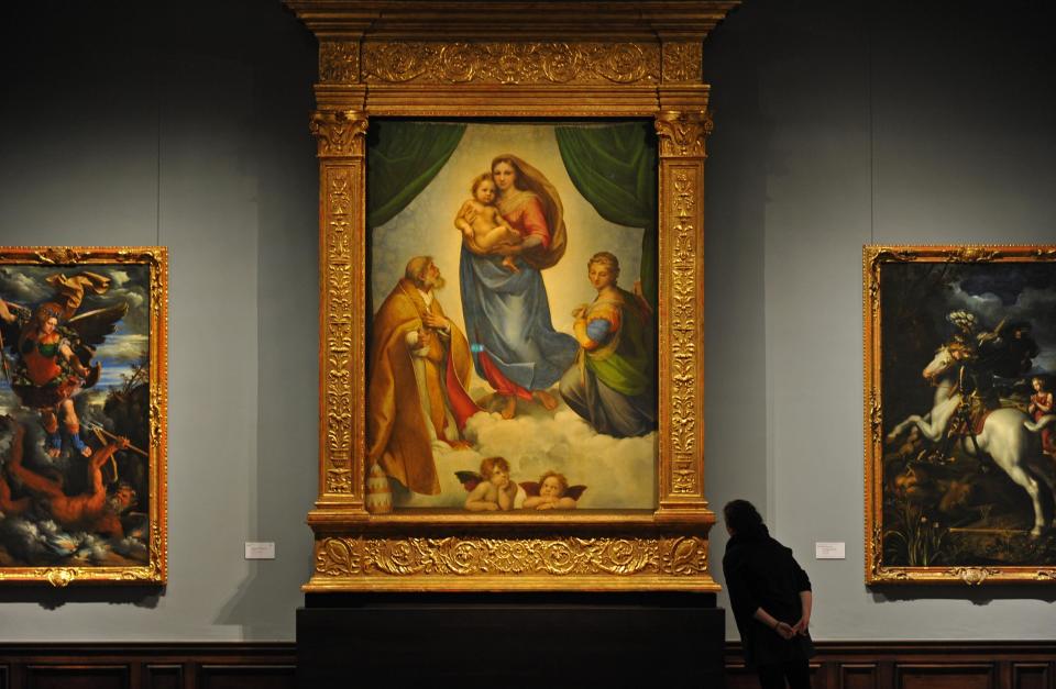 A woman observes Raffael's 'Sistine Madonna' from 1513 at the Gobelin hall of the Gemaeldegalerie Alte Meister (Old Masters Picture Gallery) in Dresden, Germany, 27 March 2013.  / Credit: Matthias Hiekel/picture alliance via Getty Images
