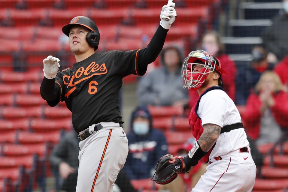 Baltimore Orioles' Ryan Mountcastle (6) follows through on his two-run double in front of Boston Red Sox's Christian Vazquez during the sixth inning of an opening day baseball game, Friday, April 2, 2021, in Boston. (AP Photo/Michael Dwyer)