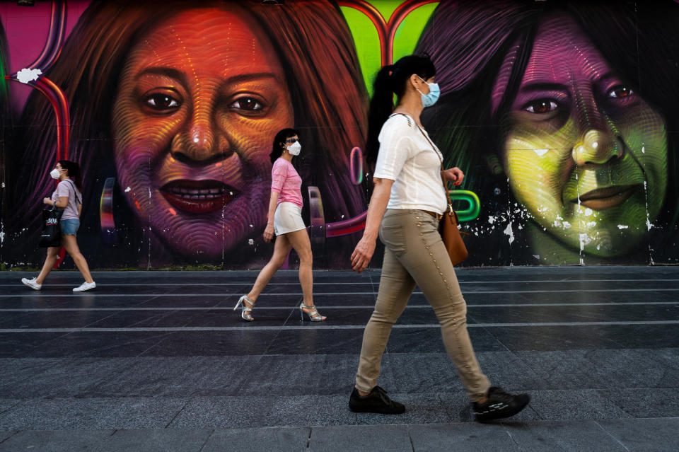 Varias mujeres caminan junto a un mural de rostros femeninos en la Gran Vía de Madrid tras el paso de la capital a la fase 1 este 25 de mayo. (Foto: Marcos del Mazo / LightRocket / Getty Images).