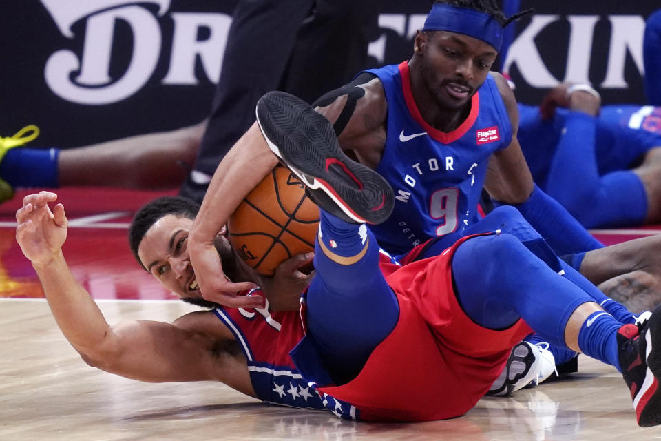 Philadelphia 76ers guard Ben Simmons and Detroit Pistons forward Jerami Grant battle for the loose ball during the second half of an NBA basketball game, Saturday, Jan. 23, 2021, in Detroit. (AP Photo/Carlos Osorio)