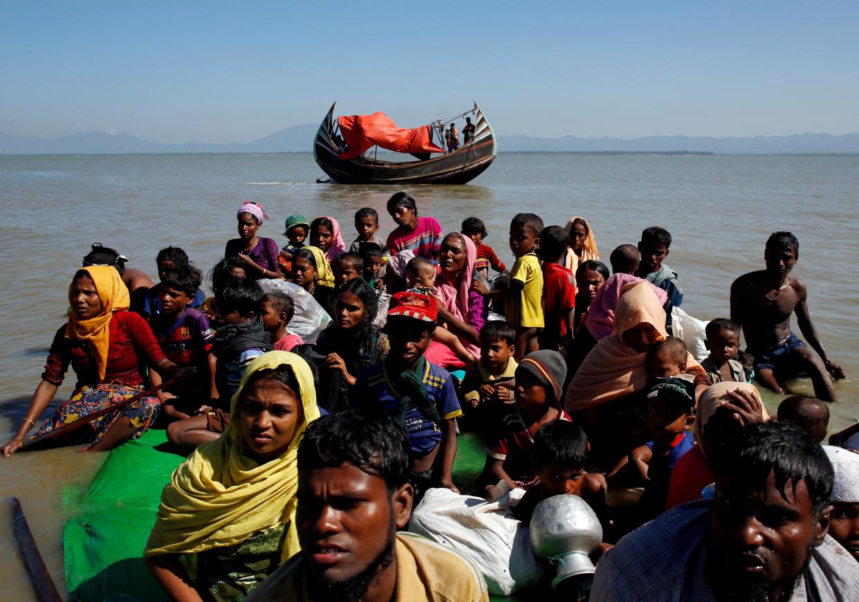 <p>Rohingya refugees sit on a makeshift boat as they are interrogated by the Bangladeshi border guard after crossing the Bangladesh-Myanmar border, at Shah Porir Dwip near Cox’s Bazar</p> (REUTERS)