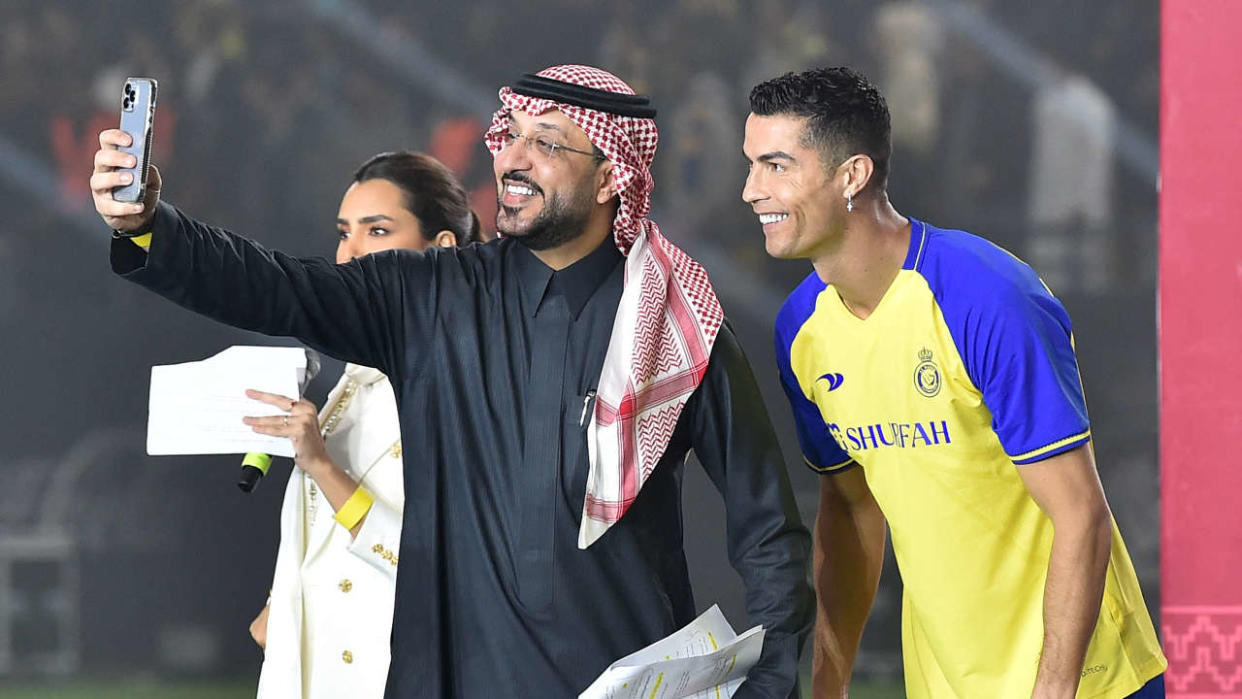 Le nouvel attaquant portugais d’Al-Nassr, Cristiano Ronaldo (R) pose pour un selfie avec les présentateurs lors de son dévoilement au stade Mrsool Park à Riyad, la capitale saoudienne, le 3 janvier 2023. (Photo de l’AFP)