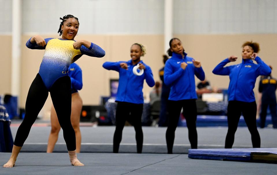 Fisk University gymnast Naimah Muhammad competes in the floor exercise as teammates watch during the Tennessee Collegiate Classic meet Friday, Jan. 20, 2023, in Lebanon, Tenn. Fisk is the first historically Black university to have an intercollegiate women’s gymnastics team.