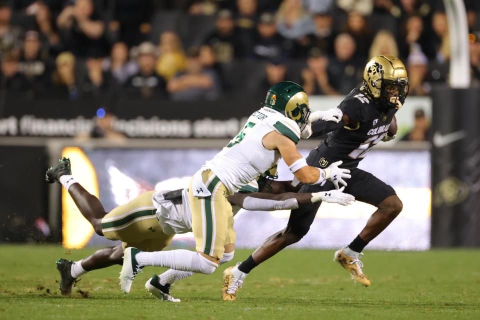 Colorado receiver Travis Hunter evades two Colorado State defenders at Folsom Field Saturday in Boulder, Colo.