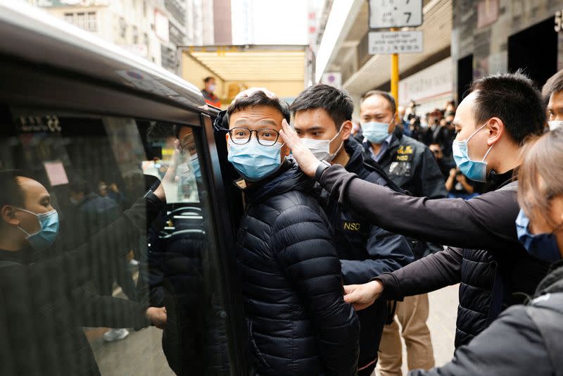 FILE PHOTO: Stand News acting chief editor Patrick Lam is escorted by police as they leave after the police searched his office in Hong Kong