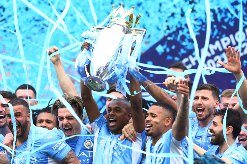 Manchester City players celebrating after winning the 2021/22 English Premier League trophy.