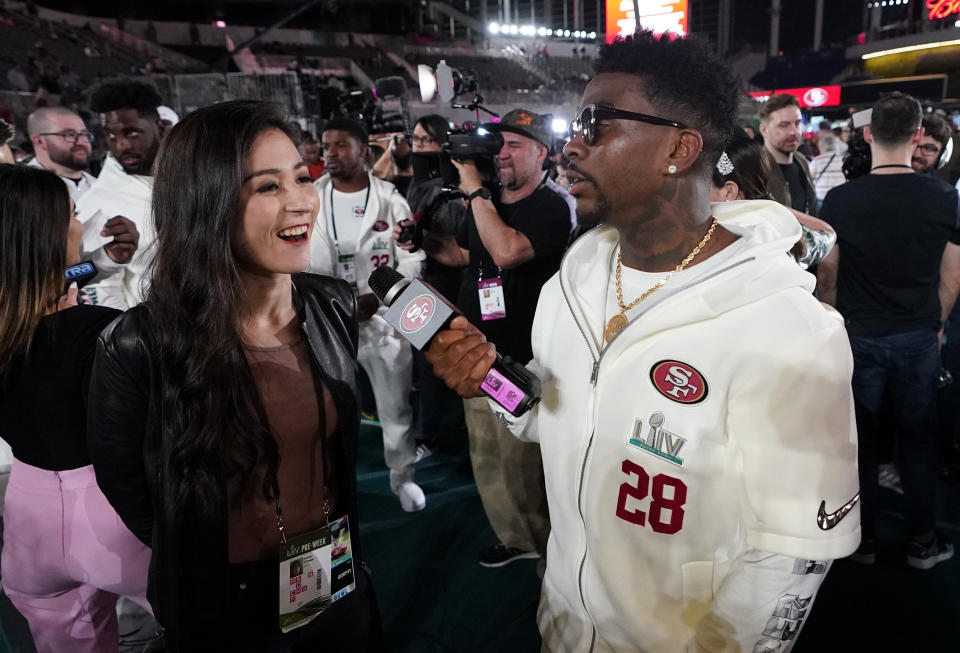 San Francisco 49ers' Jerick McKinnon interviews Mina Kimes during Opening Night for the NFL Super Bowl 54 football game Monday, Jan. 27, 2020, at Marlins Park in Miami. (AP Photo/David J. Phillip)