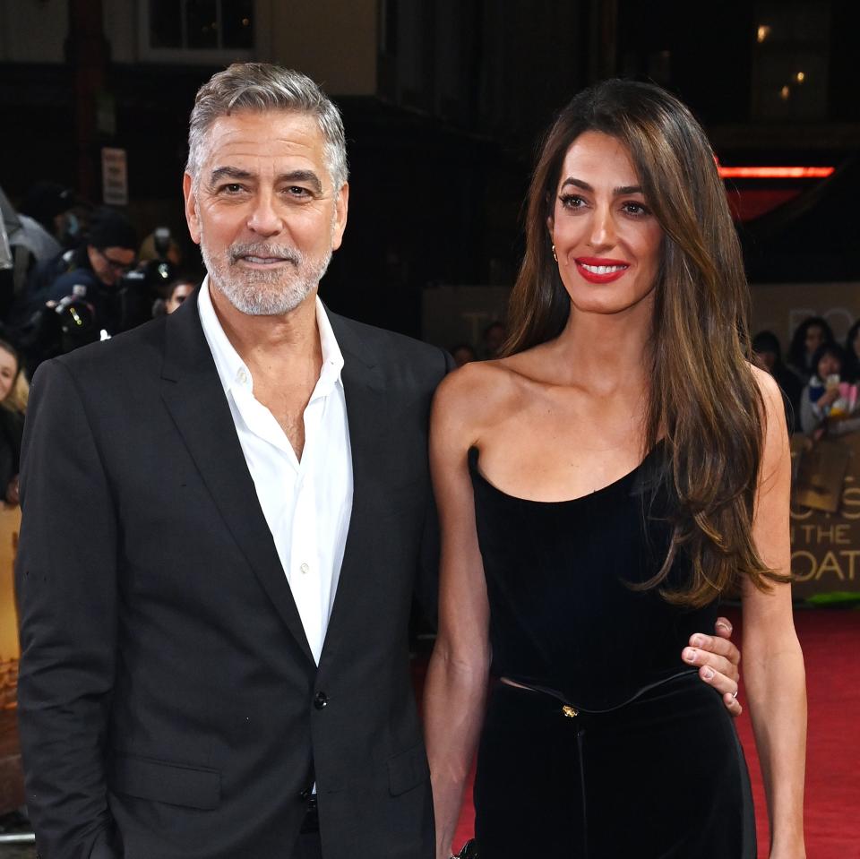 Two celebrities appeared on the red carpet.The man is wearing a gray suit and the woman is wearing a sophisticated black dress