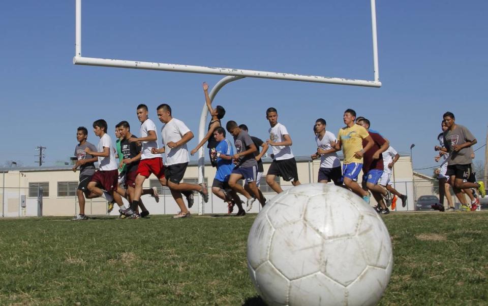 In this 2011 file photo, eam members run laps around the field during soccer practice at Northside High School.