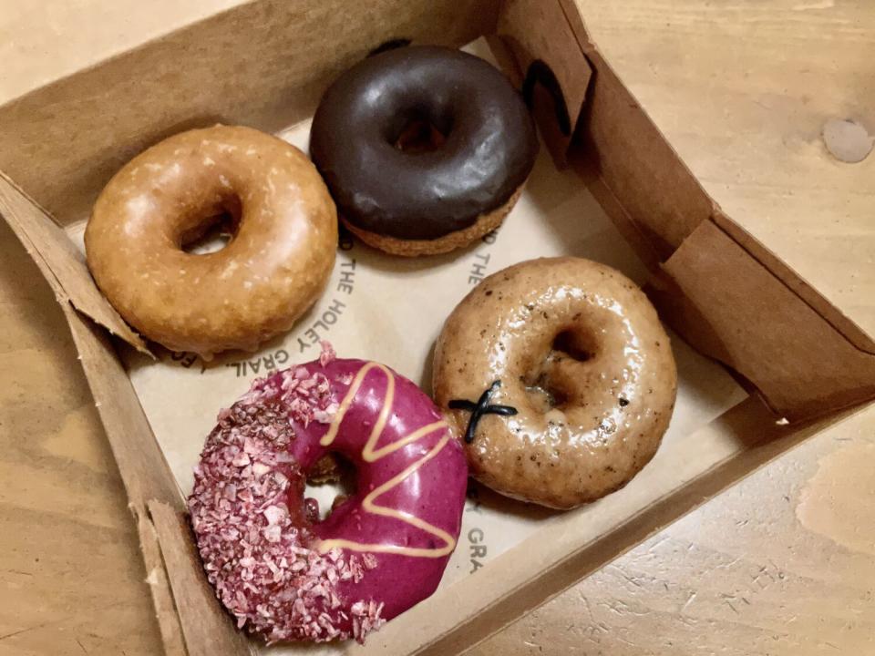 An overhead shot of four doughnuts in a box