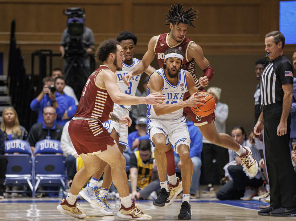 Duke's Jacob Grandison (13) holds the ball while Boston College's Jaeden Zackery (3) and T.J. Bickerstaff, right, defend during the first half of an NCAA college basketball game in Durham, N.C., Saturday, Dec. 3, 2022. (AP Photo/Ben McKeown)