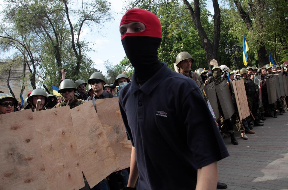 A Ukrainian government supporter walks past a line of self-defense activists during a clash with pro-Russians in the Black Sea port of Odessa, Ukraine, Friday, May 2, 2014. A clash broke out late Friday between pro-Russians and government supporters in Odessa, on the Black Sea coast some 550 kilometers (330 miles) from the turmoil in the east. Odessa had remained largely untroubled by unrest since the February toppling of pro-Russia President Viktor Yanukovych, which ignited tensions in the east. (AP Photo/Sergei Poliakov)