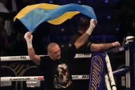 Oleksandr Usyk of Ukraine holds up the Ukrainian flag after his unanimous decision victory over Anthony Joshua of Britain in their WBA (Super), WBO and IBF boxing title bout at the Tottenham Hotspur Stadium in London, Saturday, Sept. 25, 2021. (AP Photo/Frank Augstein)