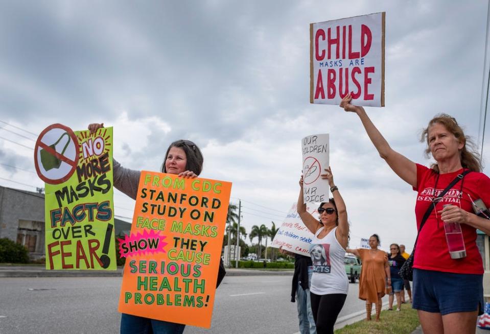 Anti-mask demonstrators stand outside the Palm Beach County School Board meeting as before a discussion on whether masks will continue to be mandatory when the new school year begins in August.