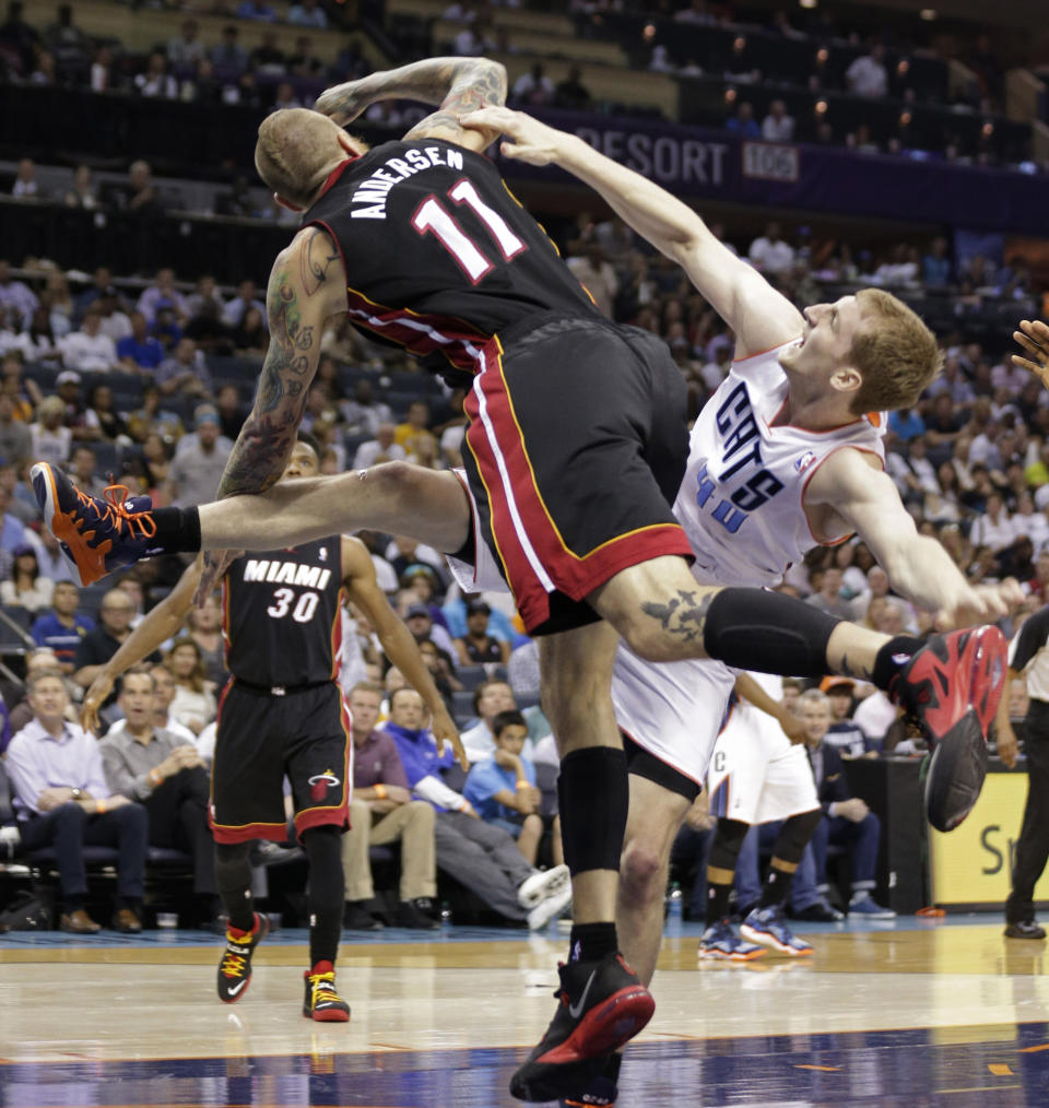 Charlotte Bobcats' Cody Zeller, right, falls as he is fouled by Miami Heat's Chris Andersen, left, during the first half in Game 4 of an opening-round NBA basketball playoff series in Charlotte, N.C., Monday, April 28, 2014. (AP Photo/Chuck Burton)