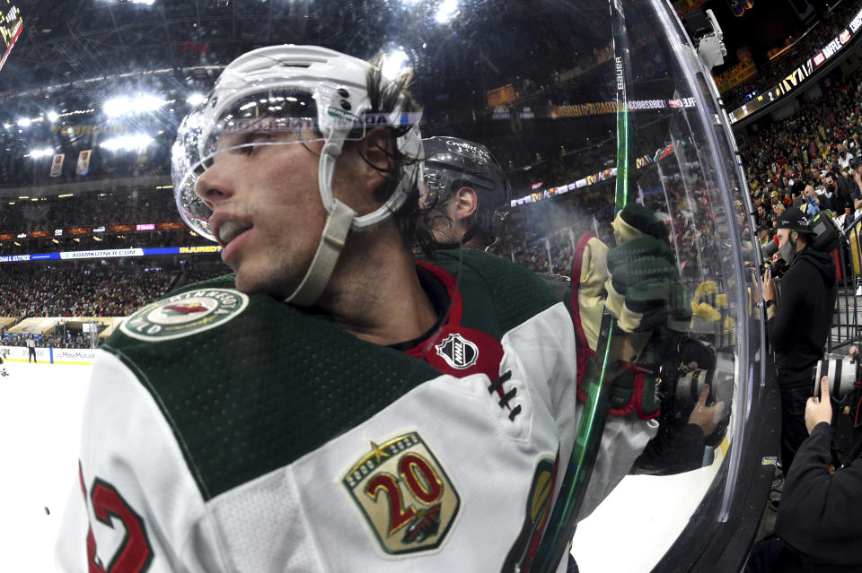 Minnesota Wild left wing Kevin Fiala (22) is checked against the glass by a Vegas Golden Knights player during the third period of Game 2 of a first-round NHL hockey playoff series Tuesday, May 18, 2021, in Las Vegas. (AP Photo/David Becker)