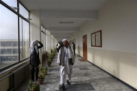 A member of the Loya Jirga, or grand council, walks at a corridor to attend a committee session in Kabul November 22, 2013. REUTERS/Omar Sobhani