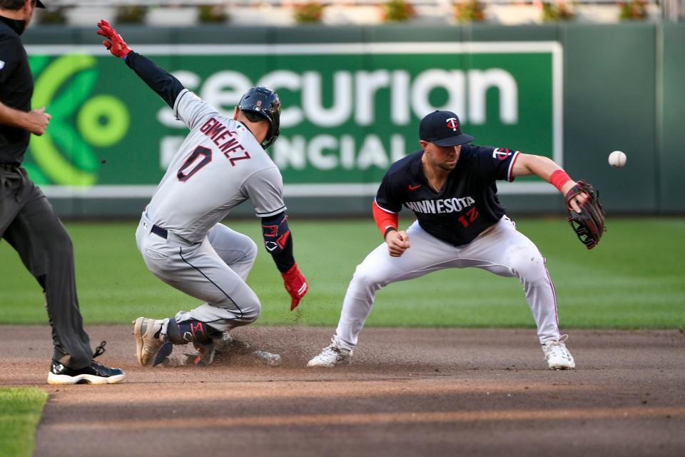 Cleveland Guardians'  Andres Gimenez (0) is safe at second after hitting a double before Minnesota Twins shortstop Kyle Farmer (12) can make a tag during the fourth inning of a baseball game, Saturday, June 3, 2023, in Minneapolis.  (AP Photo/Craig Lassig)