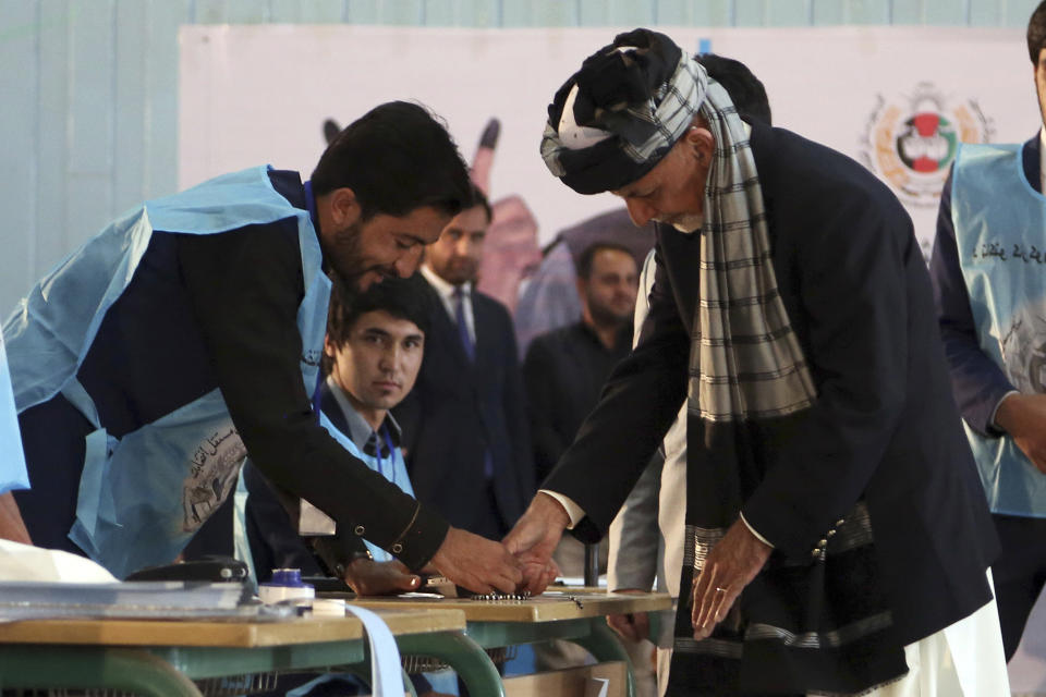 Afghan President Ashraf Ghani, right, inks his finger during the presidential election before he casts his vote at Amani high school, near the presidential palace in Kabul, Afghanistan, Saturday, Sept. 28, 2019. Afghans headed to the polls on Saturday to elect a new president amid high security and Taliban threats to disrupt the elections, with the rebels warning citizens to stay home or risk being hurt. (AP Photo/Rahmat Gul)