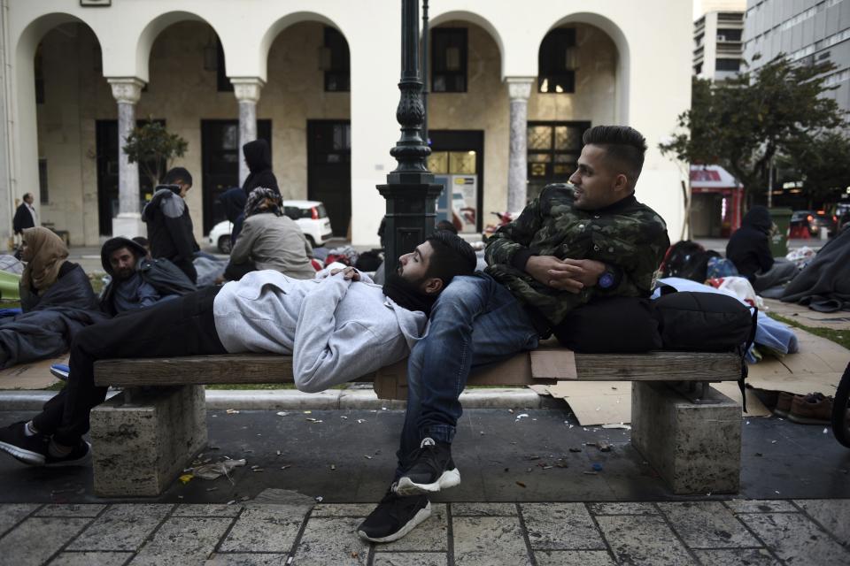 Kurdish migrants wait outside a police station in Aristotelous Square at the northern Greek city of Thessaloniki, Monday, Oct. 8, 2018. Dozens of refugees and migrants have gathered outside a police station in Greece's second largest city, waiting for hours to be formally arrested and gain temporary residence in the European Union country. (AP Photo/Giannis Papanikos)