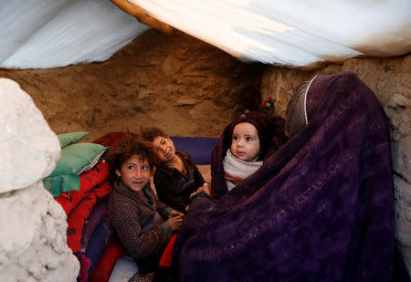 Internally displaced Afghan family sits inside a tent at a refugee camp in Herat province, Afghanistan October 14, 2018. Picture taken October 14, 2018. REUTERS/Mohammad Ismail