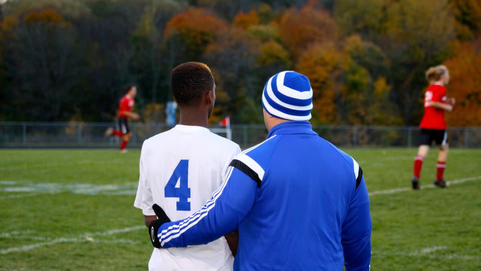 Dan Gish wraps his arm around a player at a quarterfinal game in 2016. - Courtesy Amy Bass