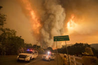 <p>Smoke blooms above the road in California. (Rex)</p>