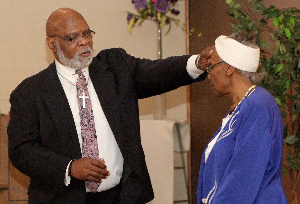 The Rev. Darryl Simmons, left, anoints Eula Guess during church service on Sunday, May 1, 2022, at First Church of God in Freeport.