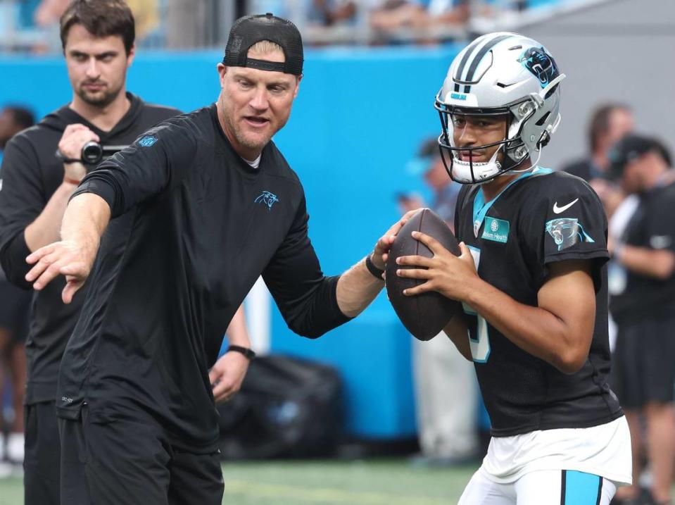 Carolina Panthers quarterbacks coach Josh McCown, left, works with rookie quarterback Bryce Young during drills at the team’s Fan Fest practice at Bank of America Stadium on Wednesday, August 2, 2023.