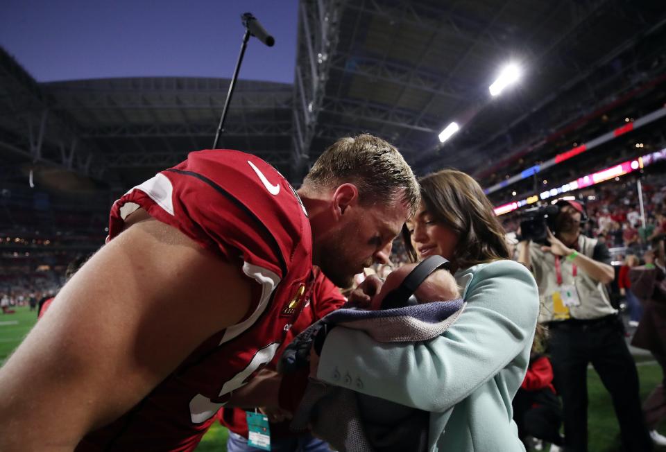 Kealia and JJ Watt embrace their 2-month-old son, Koa, after an Arizona Cardinals home game.