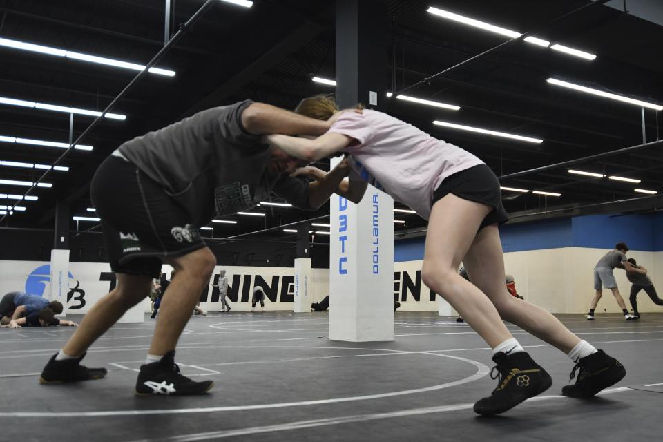 James Stettler, left, a teacher and wrestling coach in Pennsylvania's Central Dauphin schools, practices a wrestling move with daughter Abby, 13, at the D3 Training Center, Monday, Feb. 26, 2024, in Quakertown, Pa. Stettler recalled going to back-to-school nights to hand out fliers to parents about wrestling. "And they'll go, 'Oh, no, I have a daughter.' And I go, 'Well, that's great, we have a girls program,'" Stettler said. (AP Photo/Marc Levy)